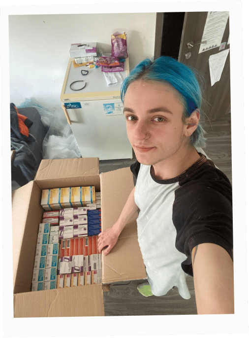 Team member Salvador holding a box of humanitarian hormone medication