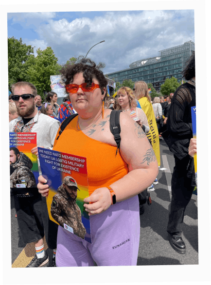 Kamiliia Safarova at Berlin Pride 2022 holding a portrait of a Ukrainian LGBTQ+ service member