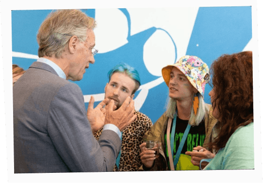 Kamiliia Safarova, Salvador Stryzh and Lev Tieriekhov speaking with Dutch Minister Robbert Dijkgraaf at the 2022 Conference against Transphobia