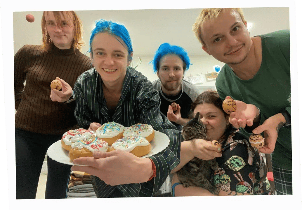 Four team members and a resident of the shelter in Slovakia holding Easter cakes
