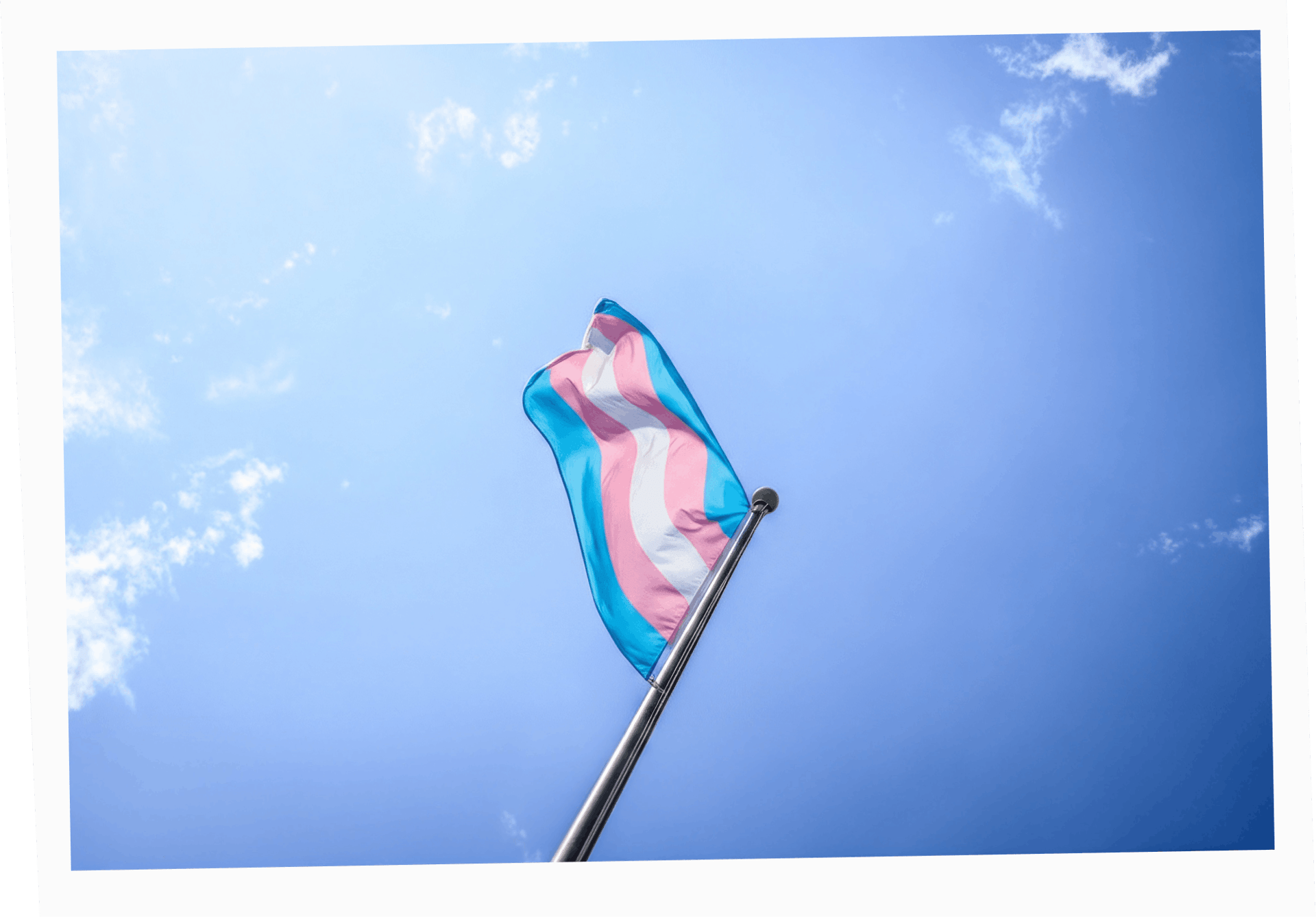 Transgender flag against an almost cloudless blue sky