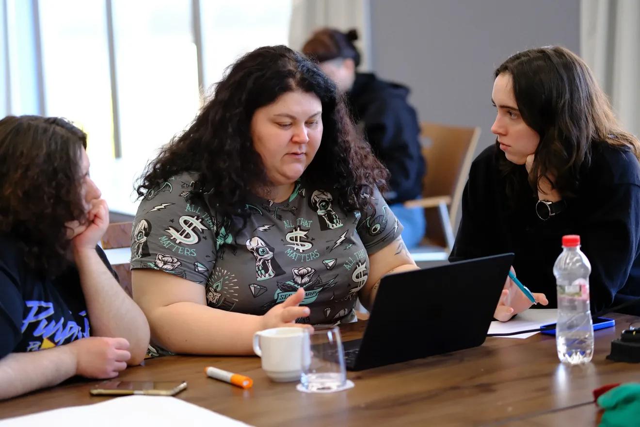 A photo of three training participants engaged in a discussion. The photo shows two staff members of the NGO Resistance.